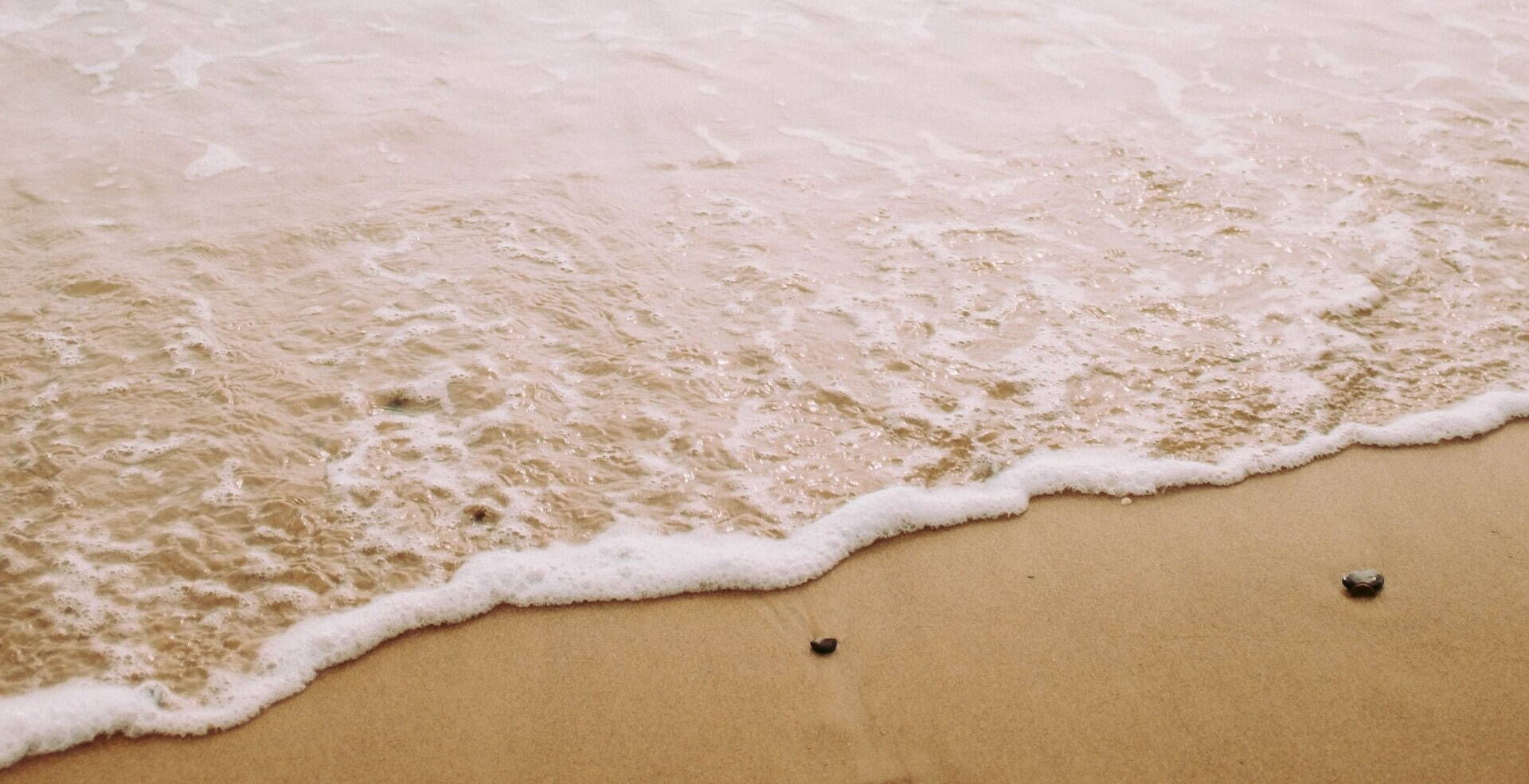 closeup of soft waves against sand